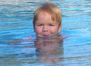 niño en agua de piscina correctamente desinfectada