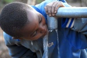 niño bebiendo agua potable de una fuente