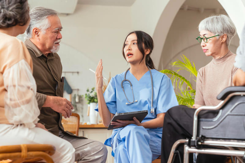 enfermera hablando con ancianos en geriátrico
