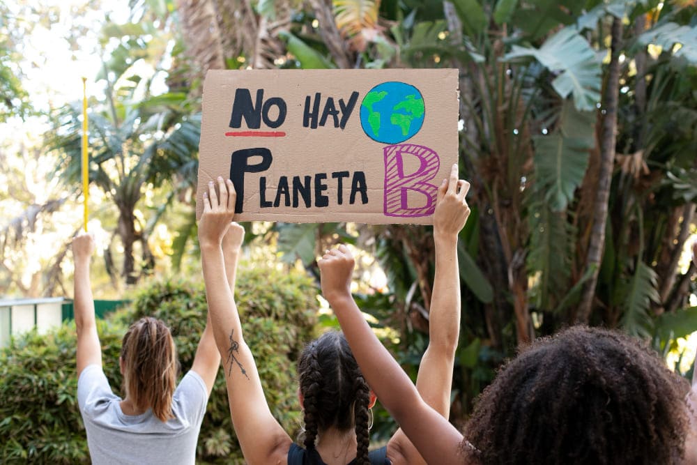 mujeres con un cartel sobre el cambio climático
